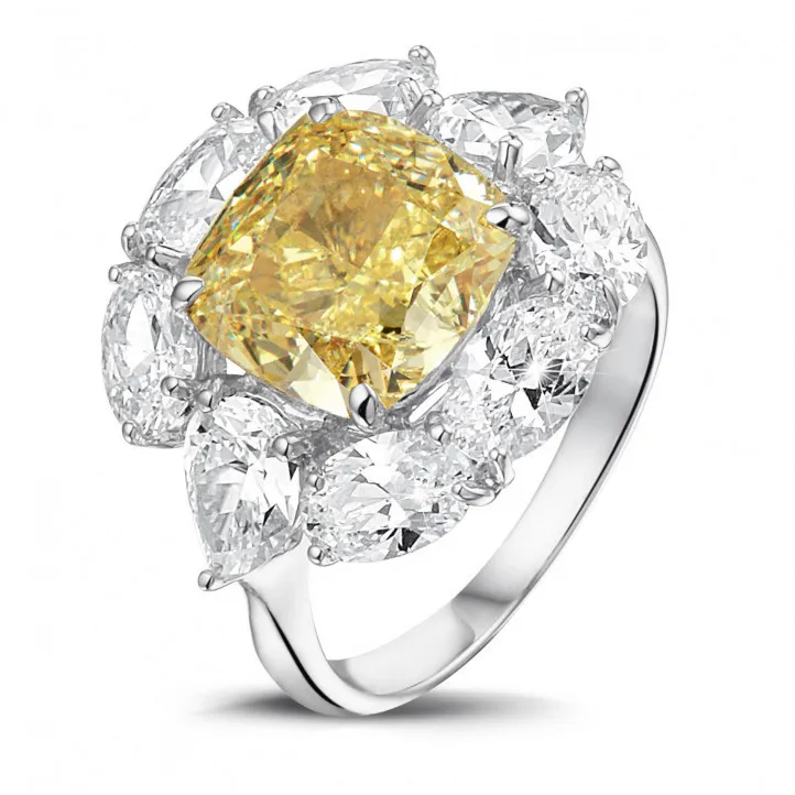 Anillo « entourage » en oro blanco con un diamante 'amarillo intenso fantasía' de talla cojín y diamantes en forma ovalado y de 